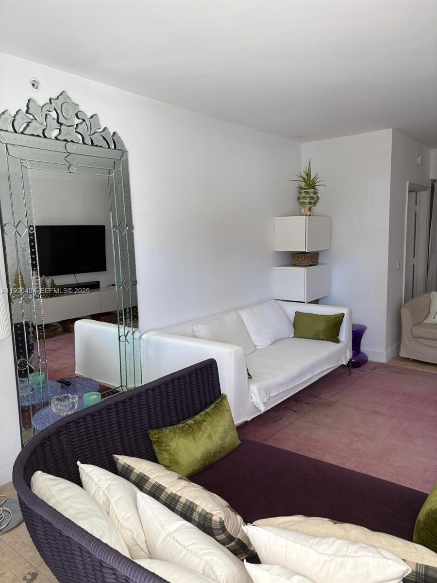 4779 Collins Avenue, Unit 504 Miami Beach, FL 33140 - Photo 16 of 45 a living room with furniture and a flat screen tv