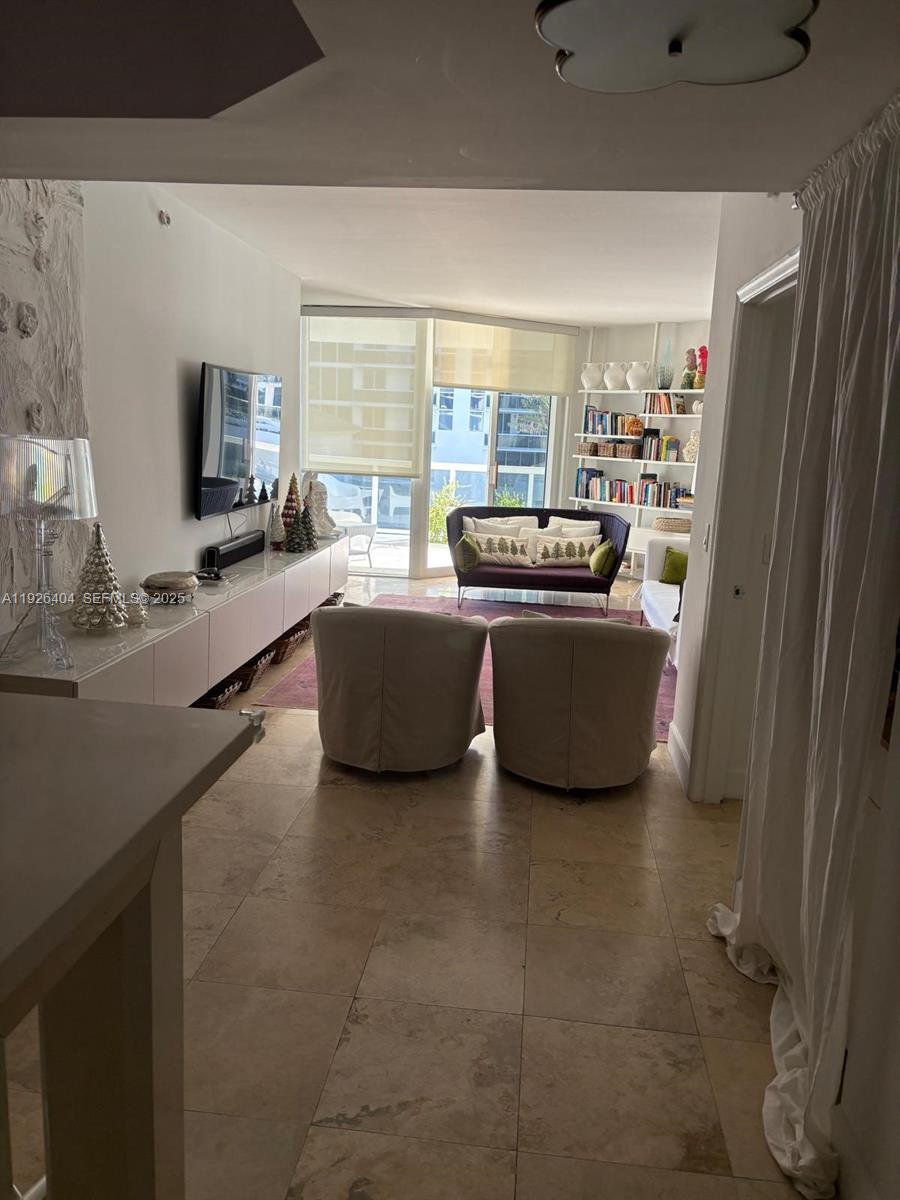 4779 Collins Avenue, Unit 504 Miami Beach, FL 33140 - Photo 21 of 45 a living room with furniture and a flat screen tv