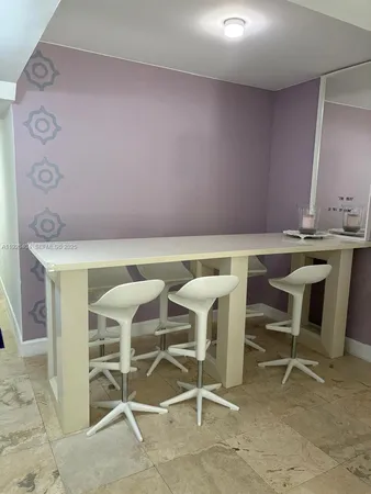 a view of a room with table chairs and wooden floor