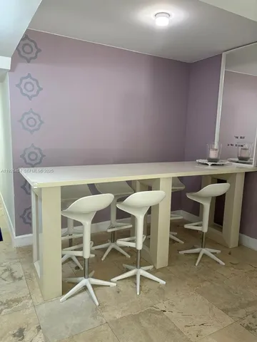 a view of a room with table chairs and wooden floor