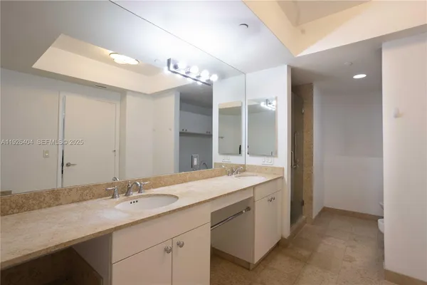 a bathroom with a granite countertop toilet and a sink