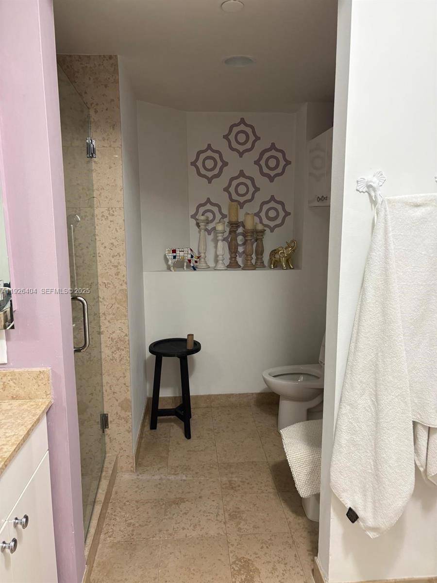 4779 Collins Avenue, Unit 504 Miami Beach, FL 33140 - Photo 33 of 45 a bathroom with a toilet and a shower curtain