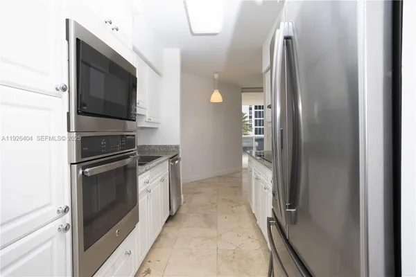 a kitchen with stainless steel appliances granite countertop a refrigerator and a stove