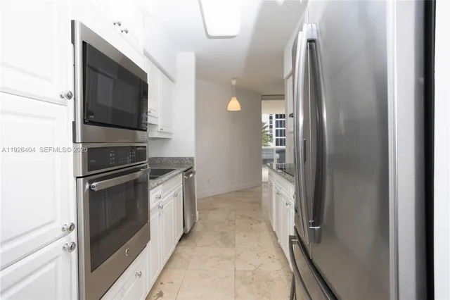 a kitchen with stainless steel appliances granite countertop a refrigerator and a stove