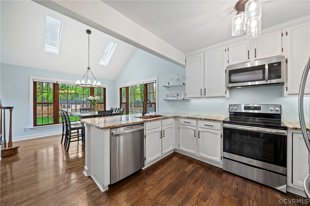 12516 Cutler Ridge Drive Henrico, VA 23233 - Photo 15 of 34 a kitchen with stainless steel appliances granite countertop a stove top oven a sink dishwasher a dining table and chairs with wooden floor