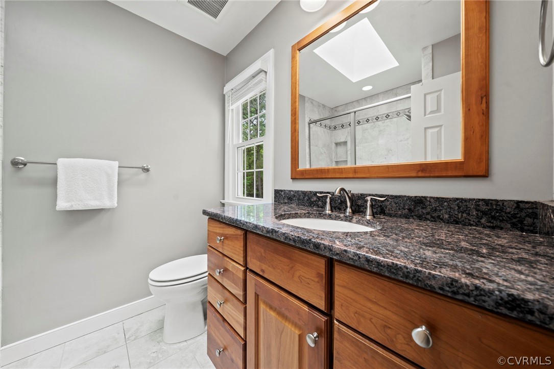 12516 Cutler Ridge Drive Henrico, VA 23233 - Photo 33 of 34 a bathroom with a granite countertop sink mirror vanity and toilet