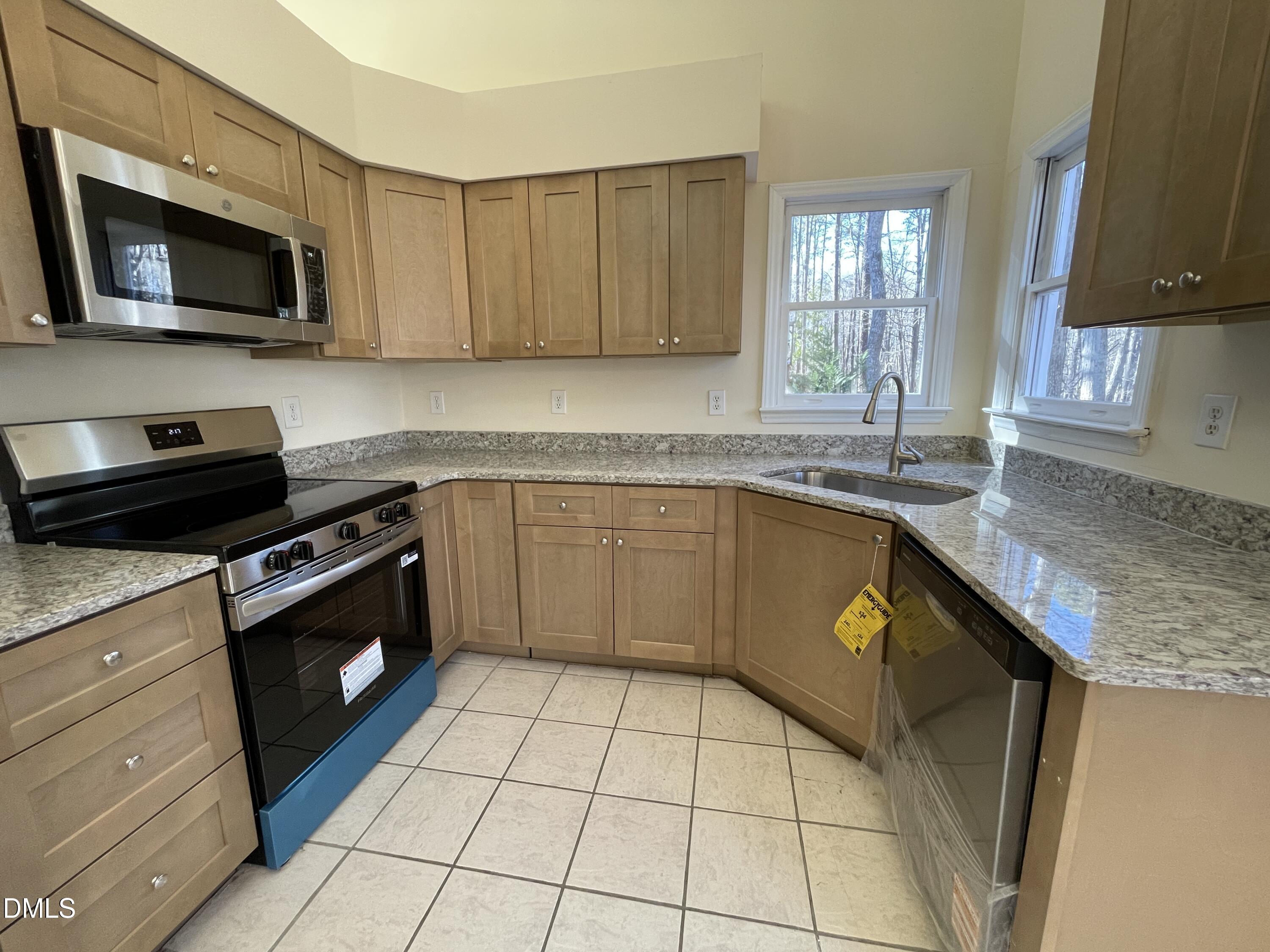 5632 Millrace Trail Raleigh, NC 27606 - Photo 11 of 26 a kitchen with a sink a stove top oven and cabinets