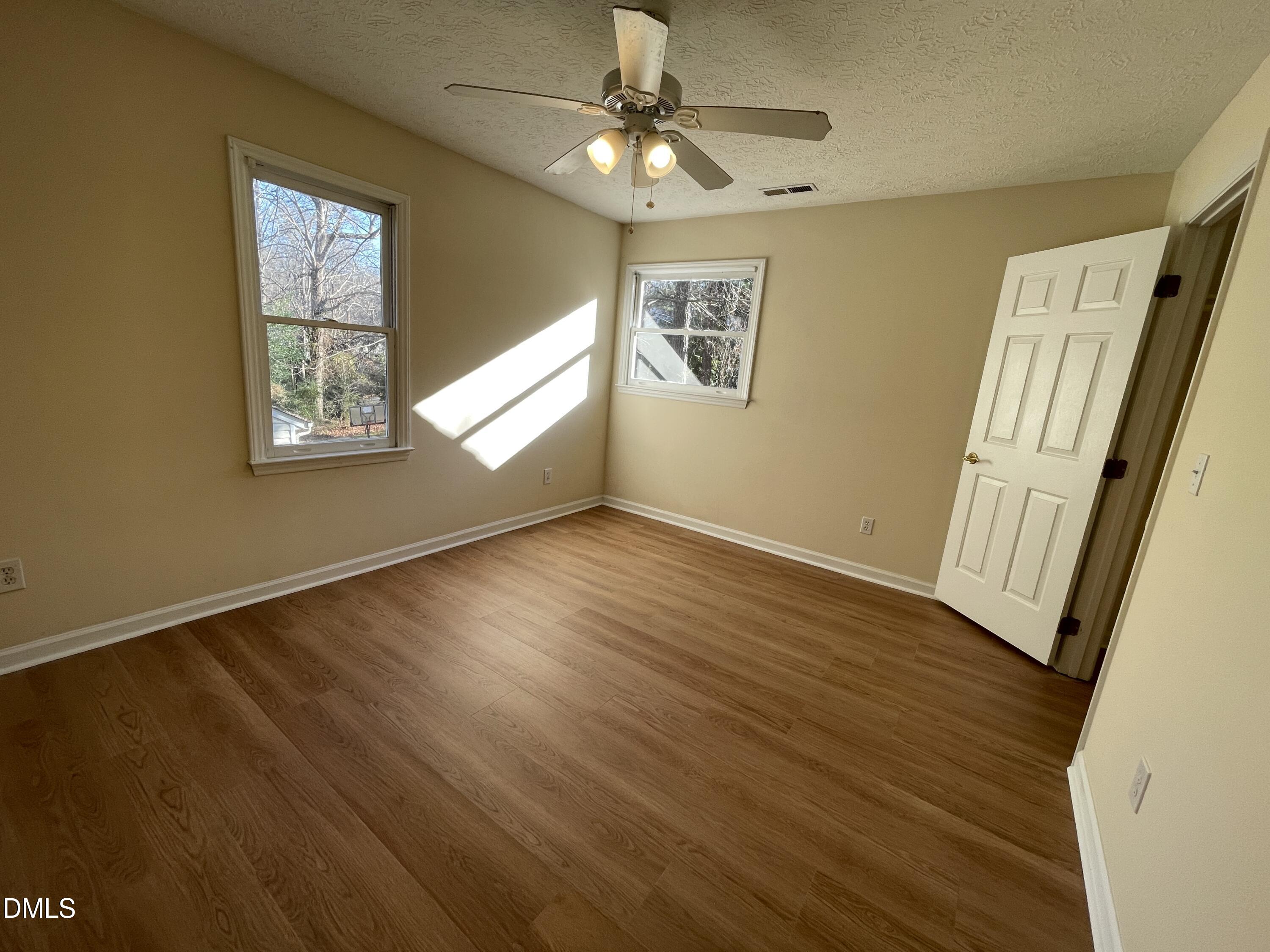 5632 Millrace Trail Raleigh, NC 27606 - Photo 17 of 26 a view of an empty room with a window and wooden floor