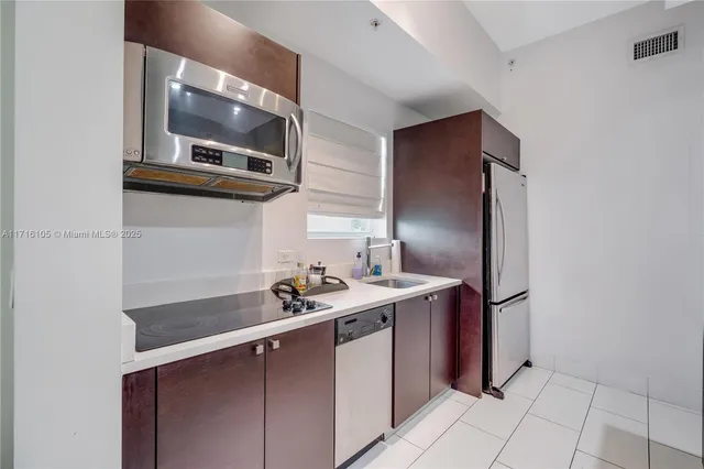 a kitchen with stainless steel appliances a sink and a microwave