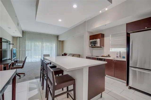 a kitchen with a table chairs refrigerator and a stove