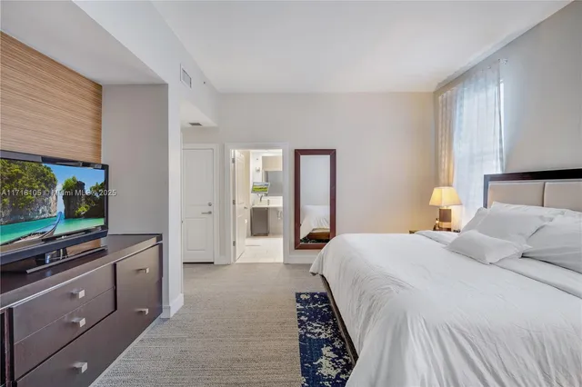 a bedroom with a bed and a flat screen tv