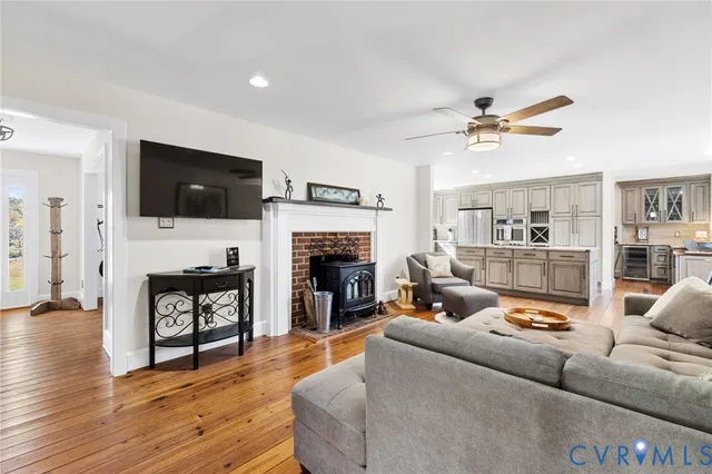a living room with furniture a fireplace a flat screen tv and kitchen view