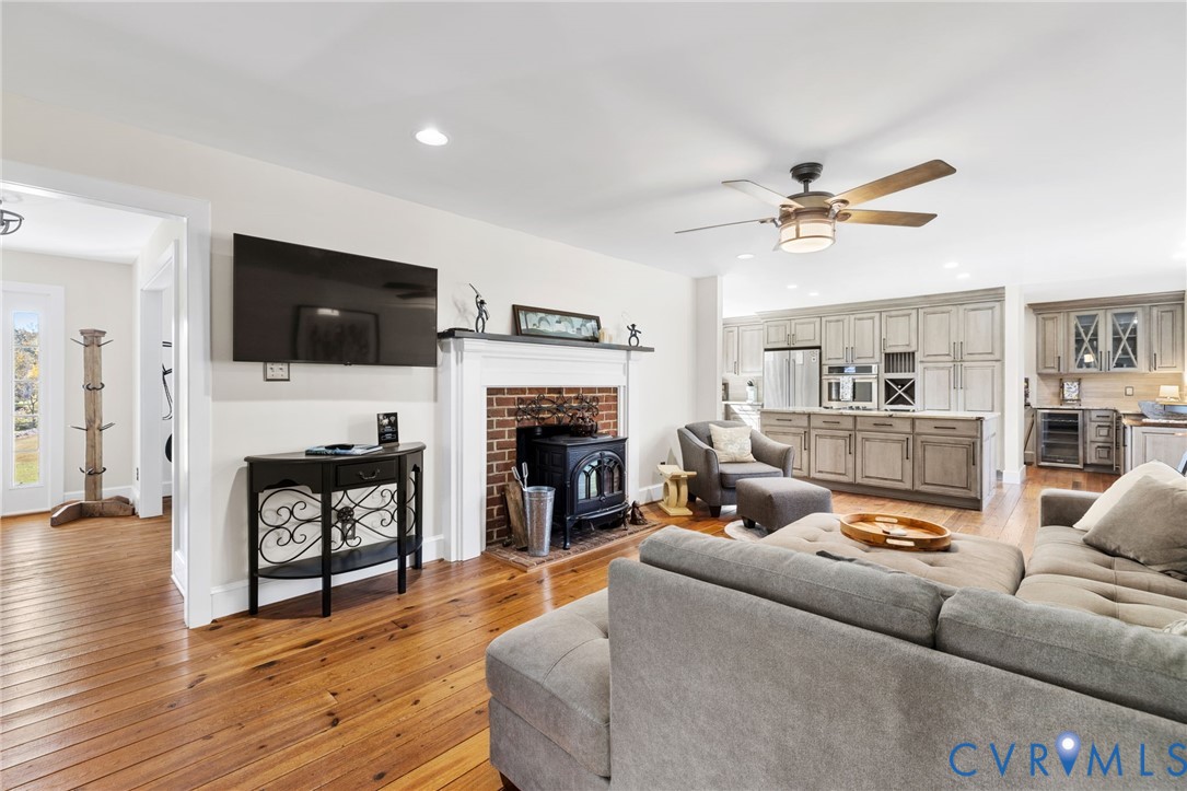 6256 Old Buckingham Road Powhatan, VA 23139 - Photo 20 of 48 a living room with furniture a fireplace a flat screen tv and kitchen view