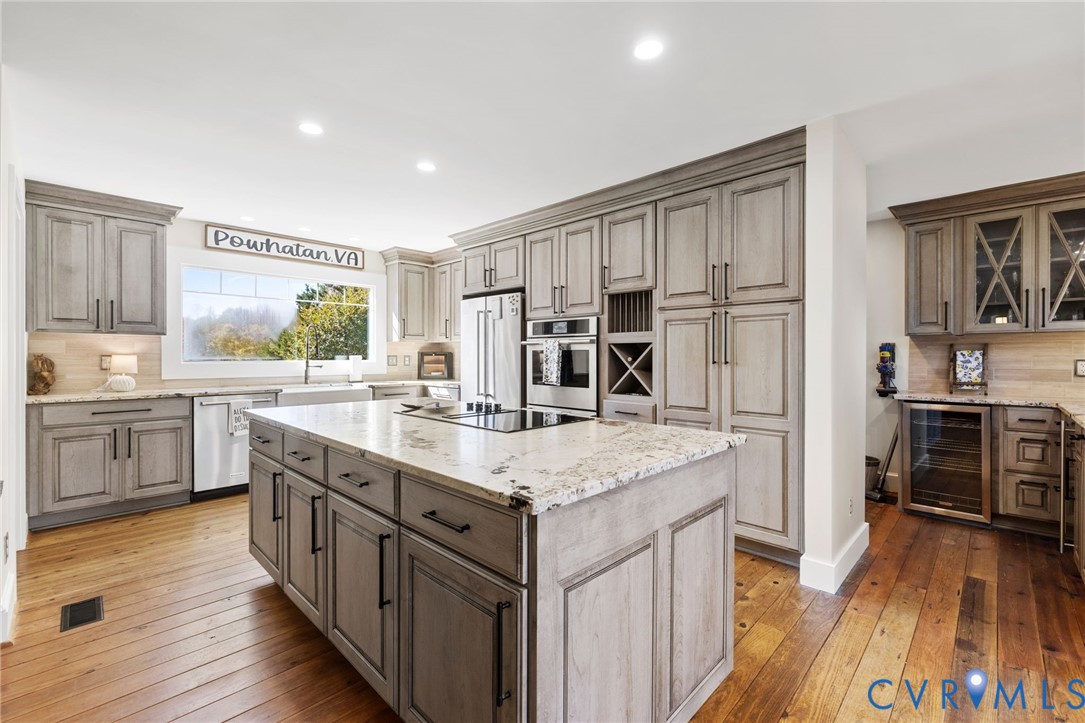 6256 Old Buckingham Road Powhatan, VA 23139 - Photo 2 of 48 a kitchen with stainless steel appliances granite countertop a kitchen island a stove a sink and a refrigerator