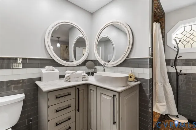 a bathroom with a sink a toilet and a mirror