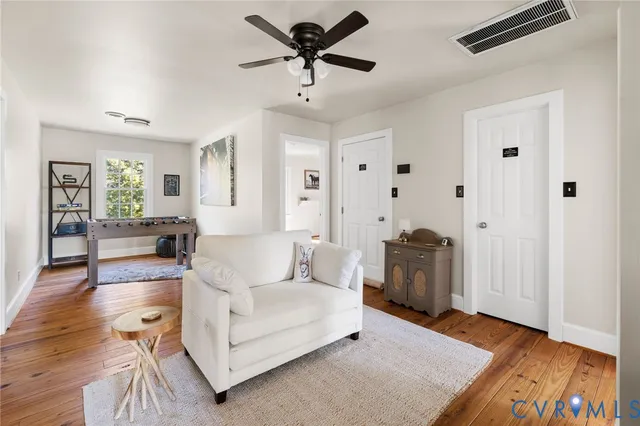 a living room with furniture and a wooden floor