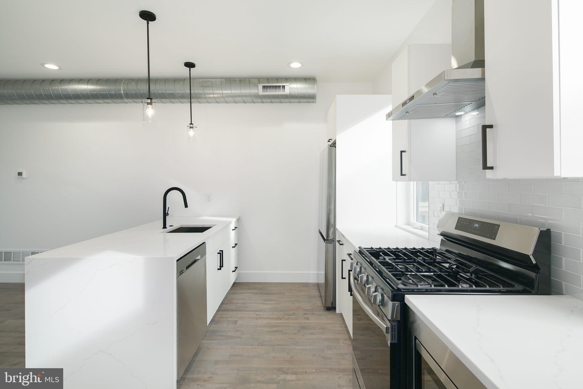 2827 Edgemont Street Philadelphia, PA 19134 - Photo 11 of 25 a kitchen with stainless steel appliances a sink stove and cabinets