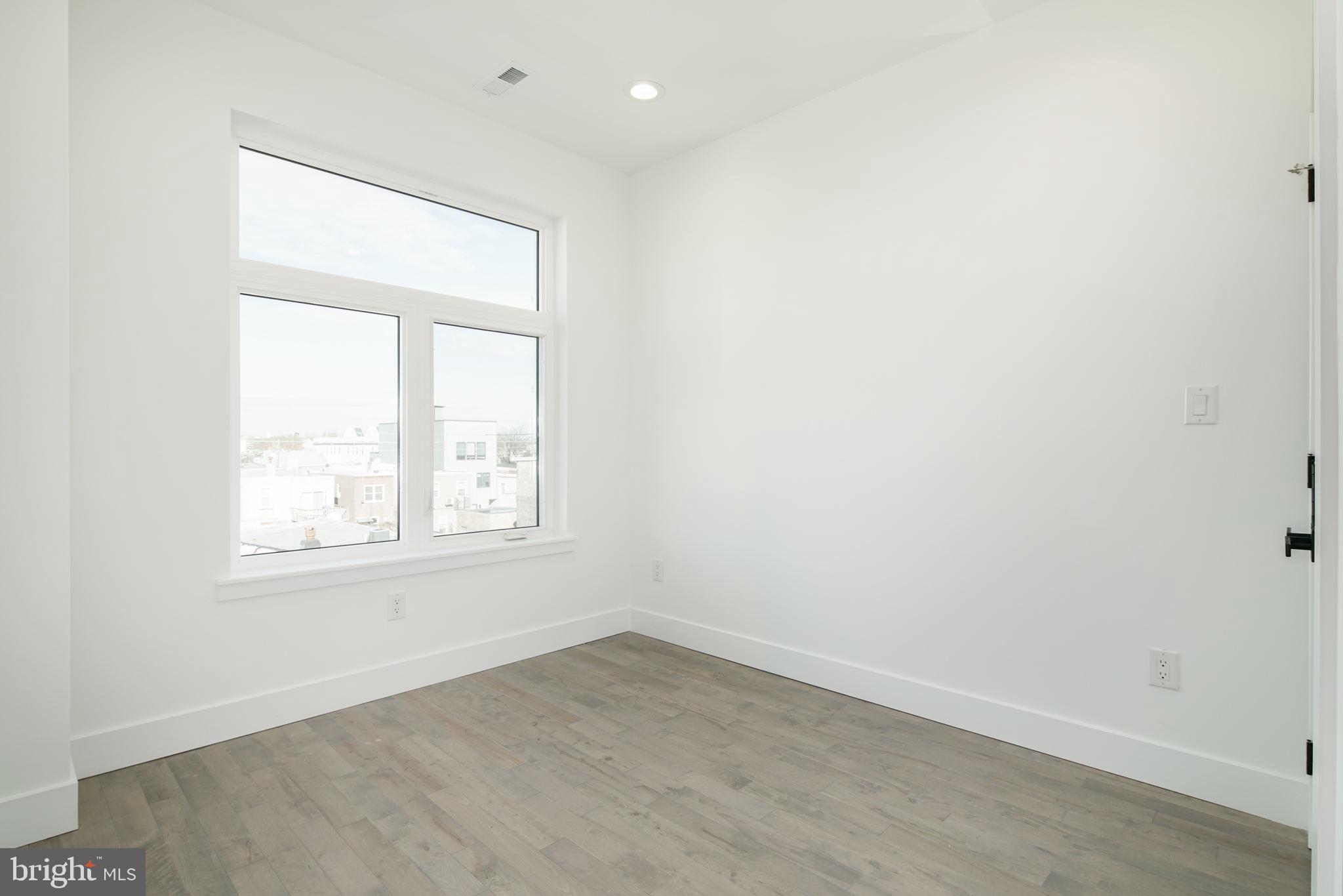 2827 Edgemont Street Philadelphia, PA 19134 - Photo 20 of 25 an empty room with wooden floor and windows