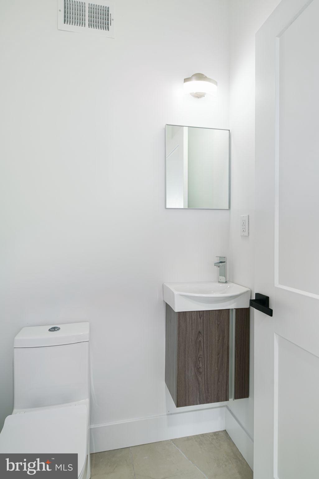 2827 Edgemont Street Philadelphia, PA 19134 - Photo 8 of 25 a bathroom with a sink a toilet and mirror