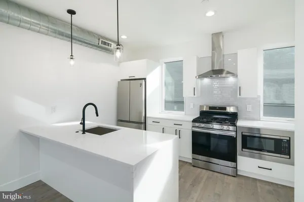 a kitchen with stainless steel appliances a stove a sink and cabinets