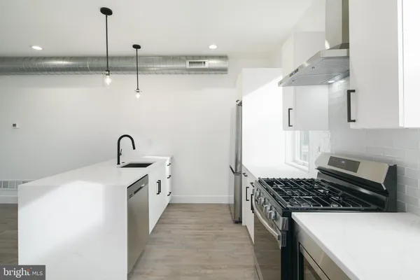 a kitchen with stainless steel appliances a sink stove and cabinets