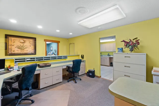 a view of a workspace with furniture and a window