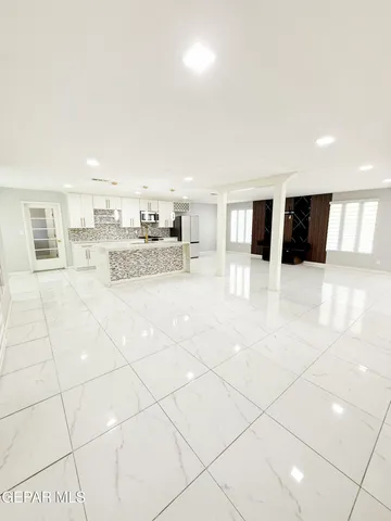 a kitchen with stainless steel appliances kitchen island granite countertop a refrigerator and a stove top oven