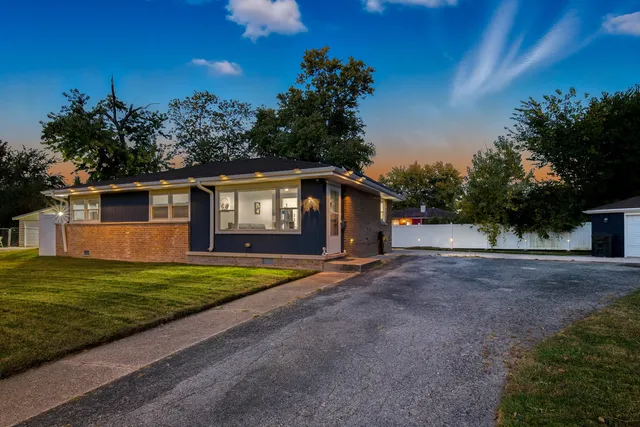 a view of a house with backyard and trees