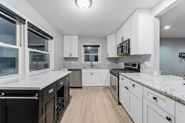 a kitchen with granite countertop a sink stove and cabinets