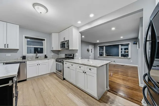 a large kitchen with stainless steel appliances granite countertop a stove and a sink