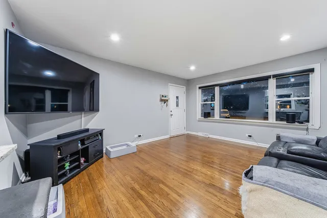 a living room with stainless steel appliances kitchen island furniture and a flat screen tv