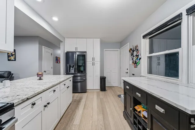 a kitchen with stainless steel appliances granite countertop a sink and a refrigerator