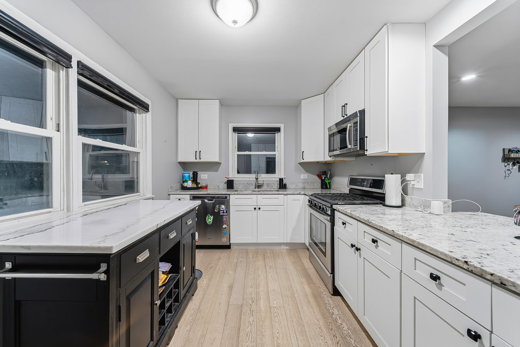 16047 Cambridge Court Markham, IL 60428 - Photo 5 of 34 a kitchen with stainless steel appliances granite countertop a stove a sink dishwasher and a microwave oven with white cabinets