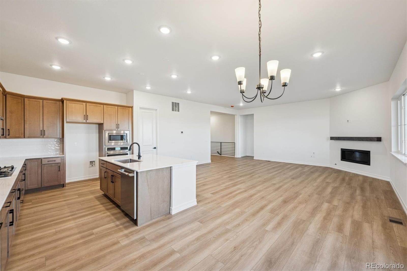 1168 Weller Street Timnath, CO 80547 - Photo 13 of 24 a kitchen with stainless steel appliances granite countertop a sink a stove and a wooden floors