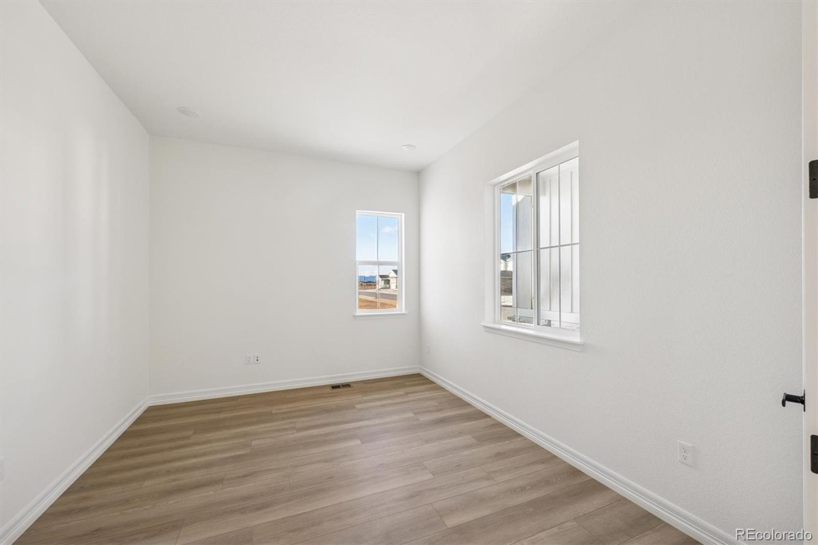 1168 Weller Street Timnath, CO 80547 - Photo 3 of 24 an empty room with wooden floor and windows