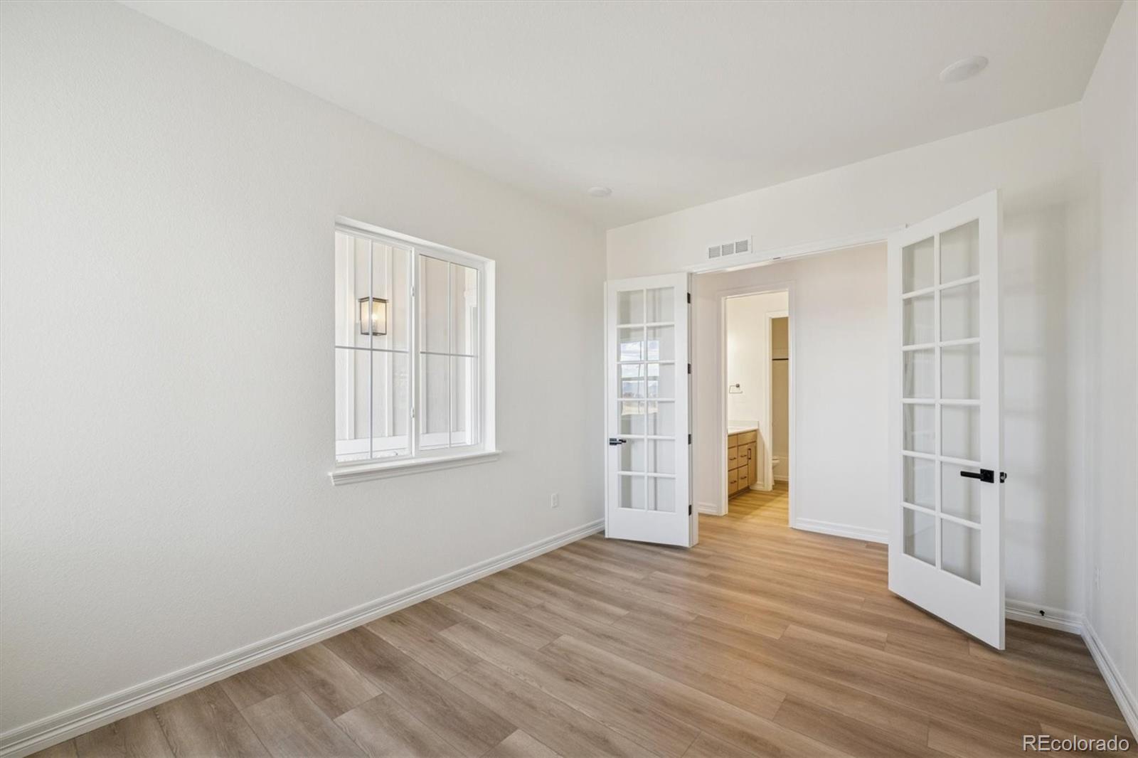 1168 Weller Street Timnath, CO 80547 - Photo 4 of 24 an empty room with wooden floor and windows