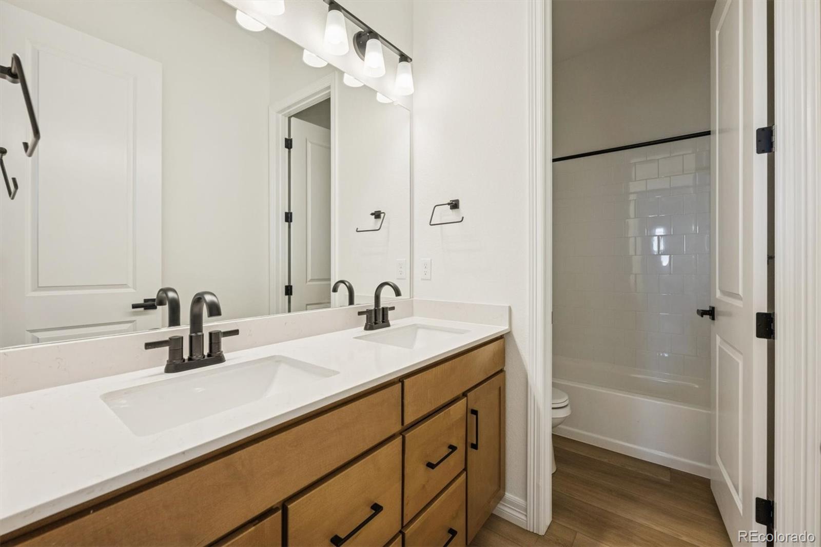 1168 Weller Street Timnath, CO 80547 - Photo 5 of 24 a bathroom with a sink and a mirror with shower