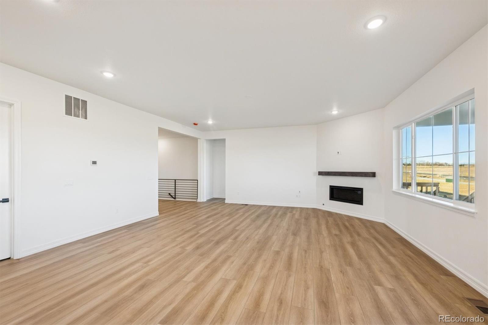 1168 Weller Street Timnath, CO 80547 - Photo 9 of 24 a view of an empty room with wooden floor and a window