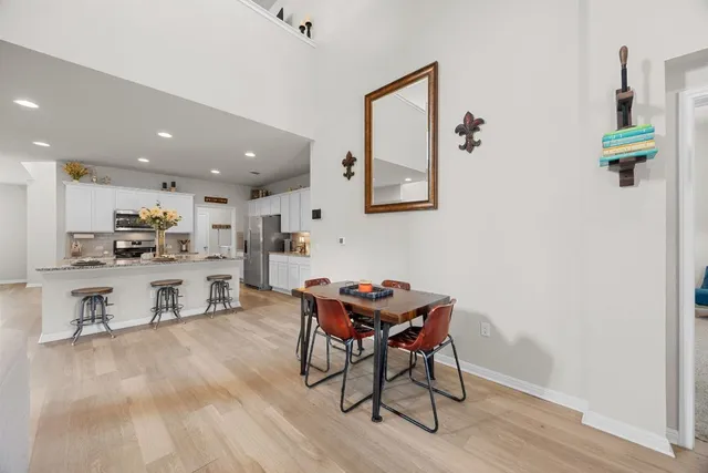 a living room with furniture and a dining table with wooden floor