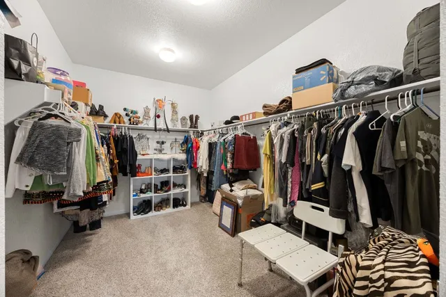 a view of walk in closet with clothes and shoes
