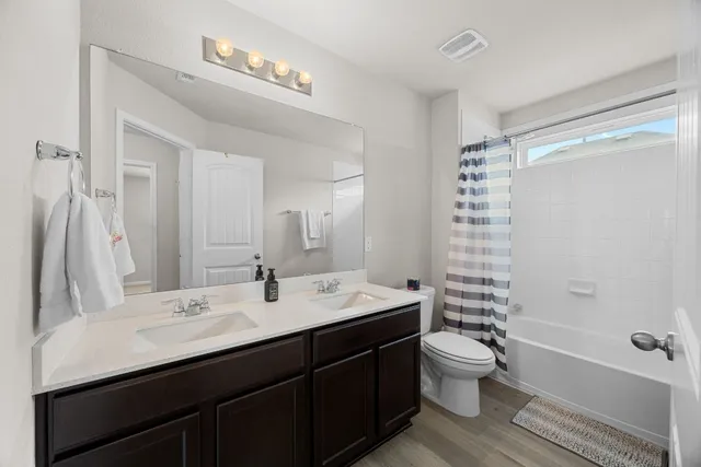 a bathroom with a double vanity sink toilet and shower