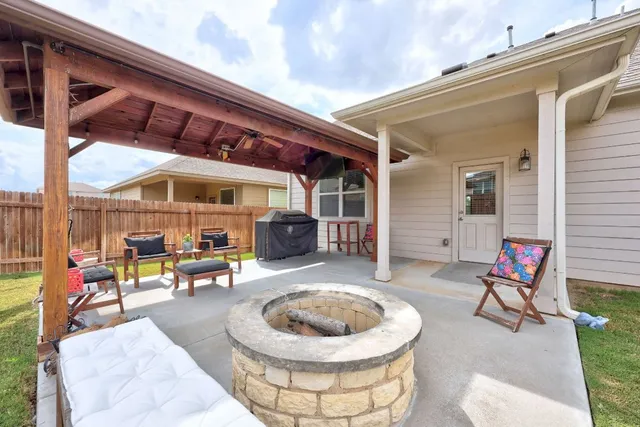 a view of a patio with a dining table and chairs with couches under an umbrella