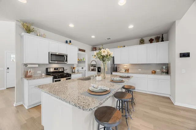 a kitchen with sink a microwave and cabinets