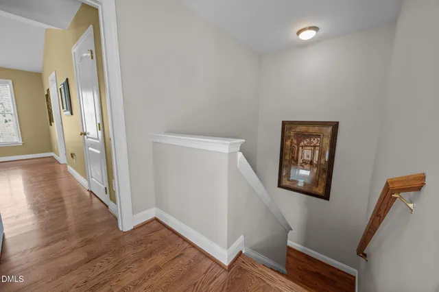 a view of a hallway with wooden floor and stairs