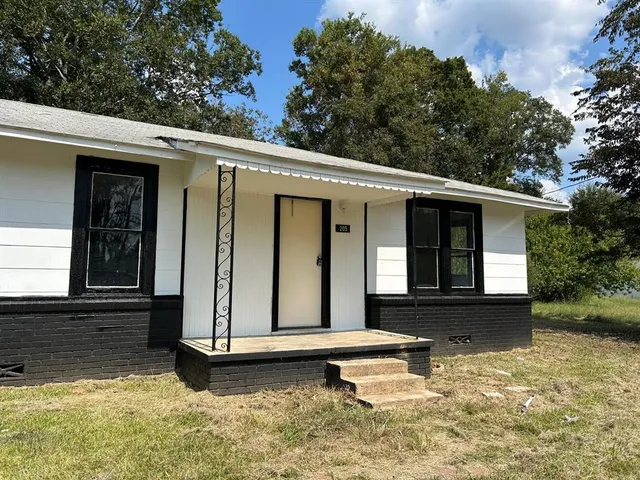 a front view of house with a garden