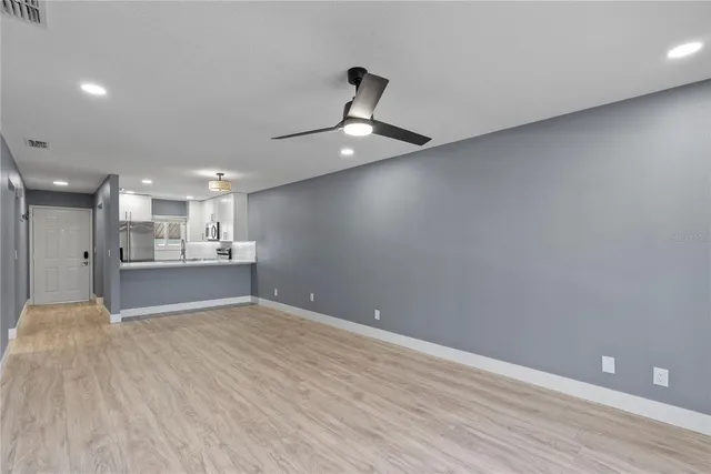 an empty room with a ceiling fan and window