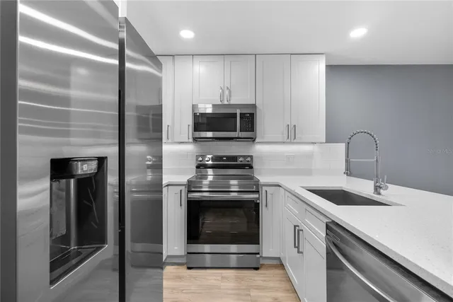 a kitchen with granite countertop a refrigerator and a sink