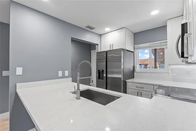 a kitchen with a sink stainless steel appliances and cabinets
