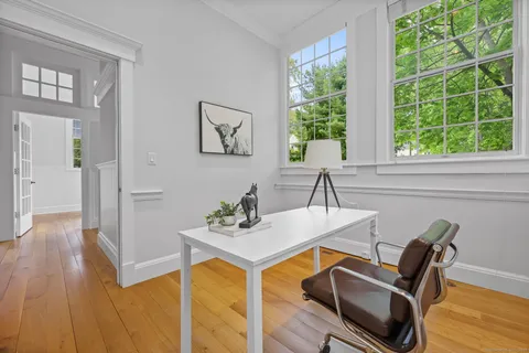 a view of a workspace with furniture and a window