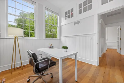 a view of a workspace with furniture and a window